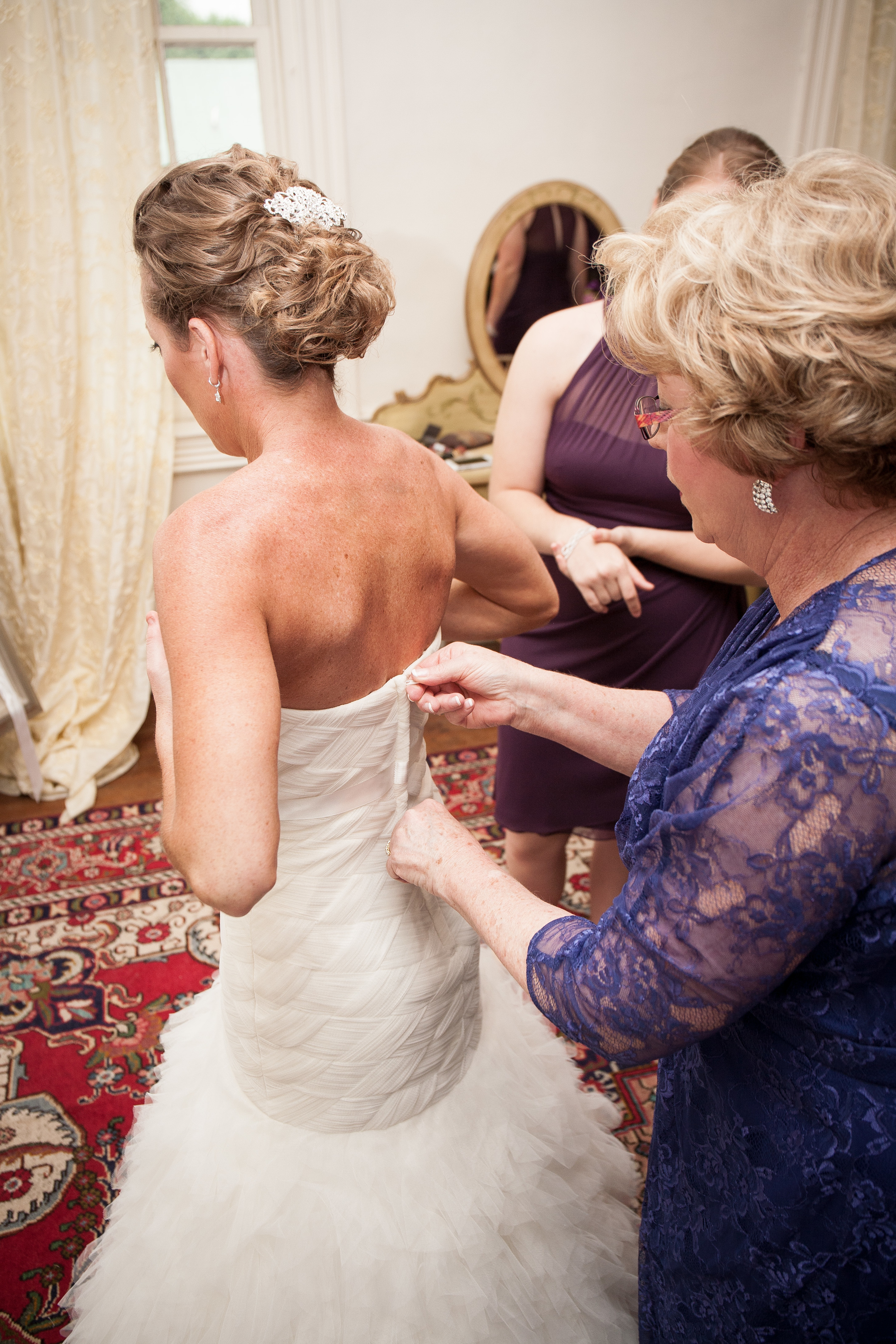 The Kyle House Fincastle Virginia Wedding Photographer Bent-Lee Carr mother of the bride helping with the wedding dress