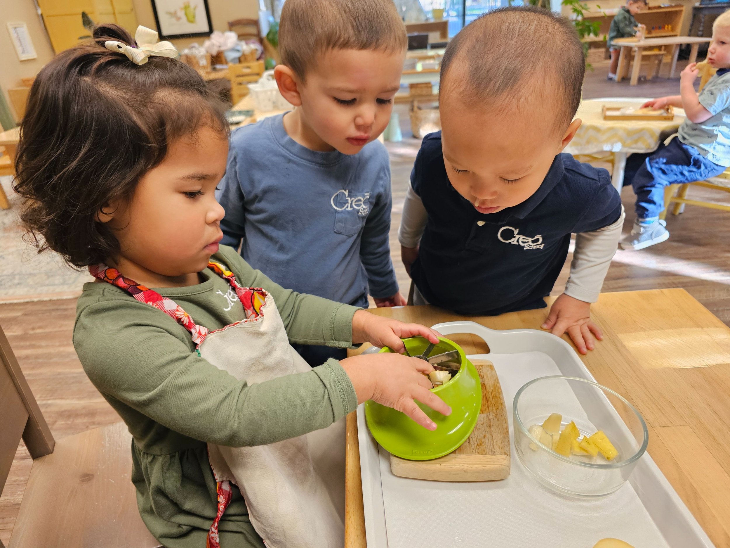 Ivy slicing pears Archie and Esteban observing.jpg