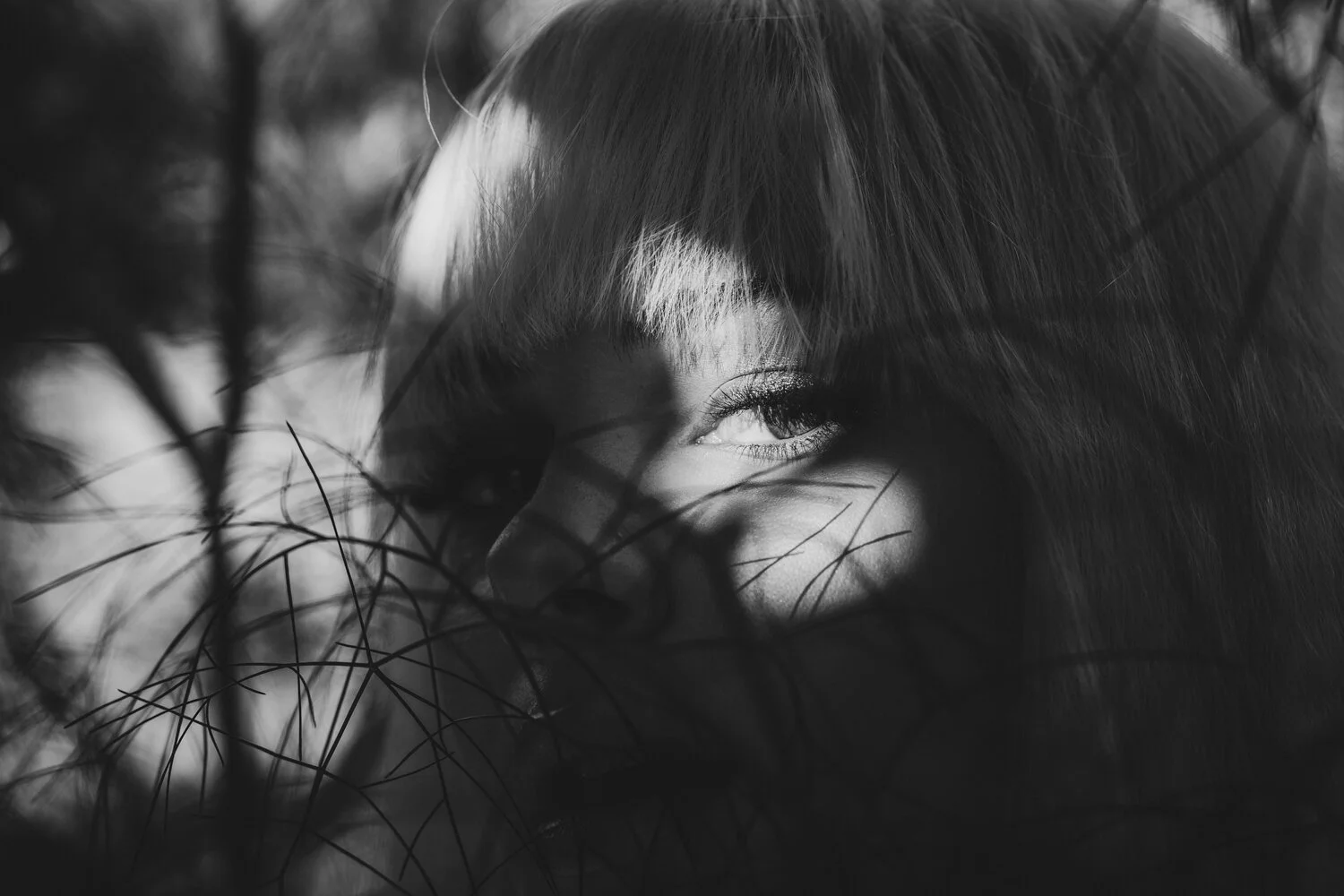 Dark shadows cover female face revealing only the eye