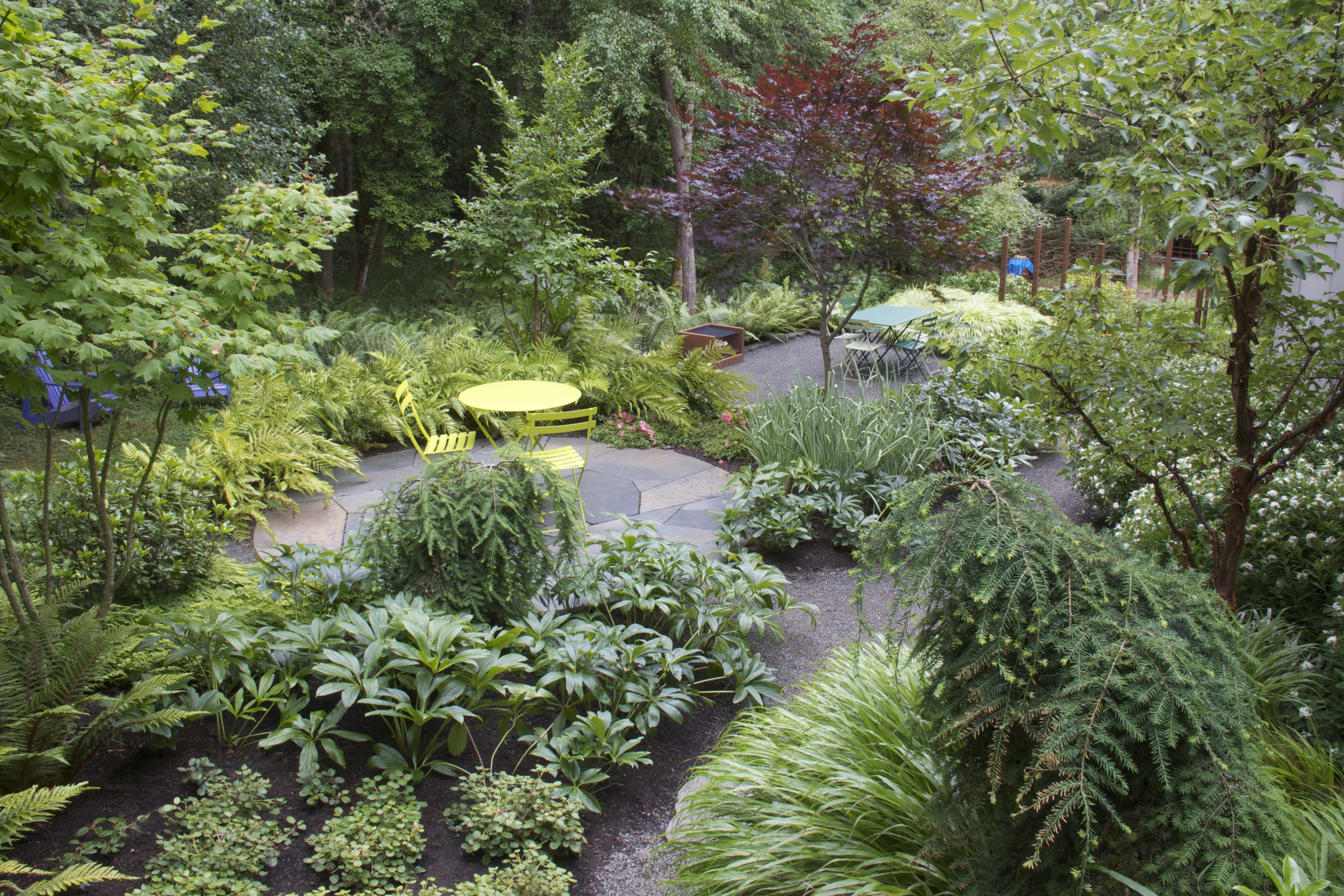  After: two garden "rooms" draw the eye, even when not in use, while plantings soften less desirable views and direct attention into the adjacent woodland. 