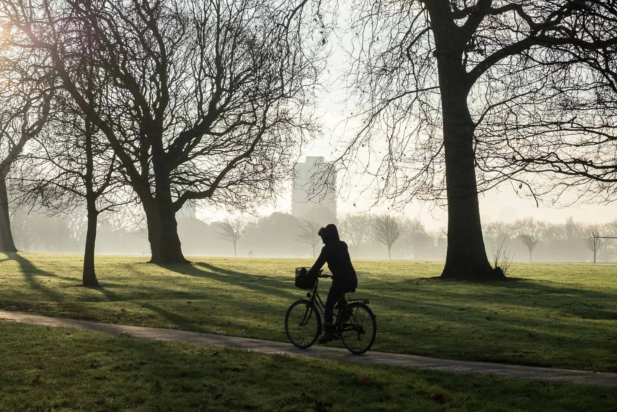 Commuter riding bicycle in Victoria Park, London