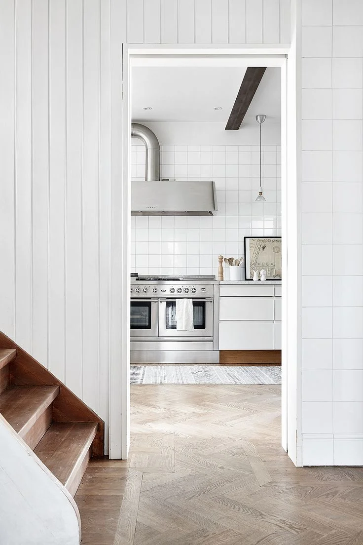 White kitchen with herringbone parquet flooring