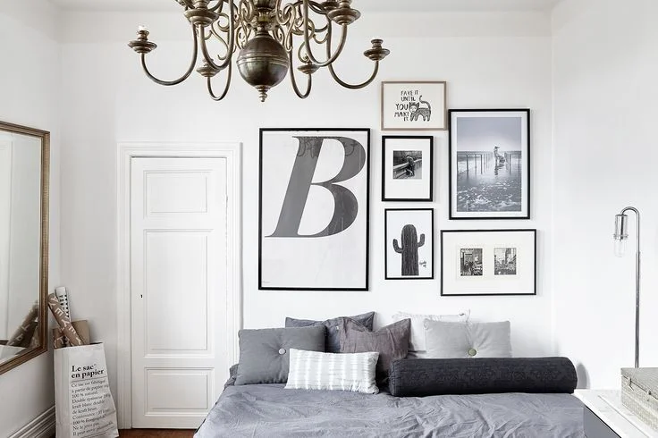 Black and white picture wall with grey cushions