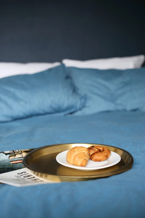 Brass breakfast tray on blue bed | Design Hunter