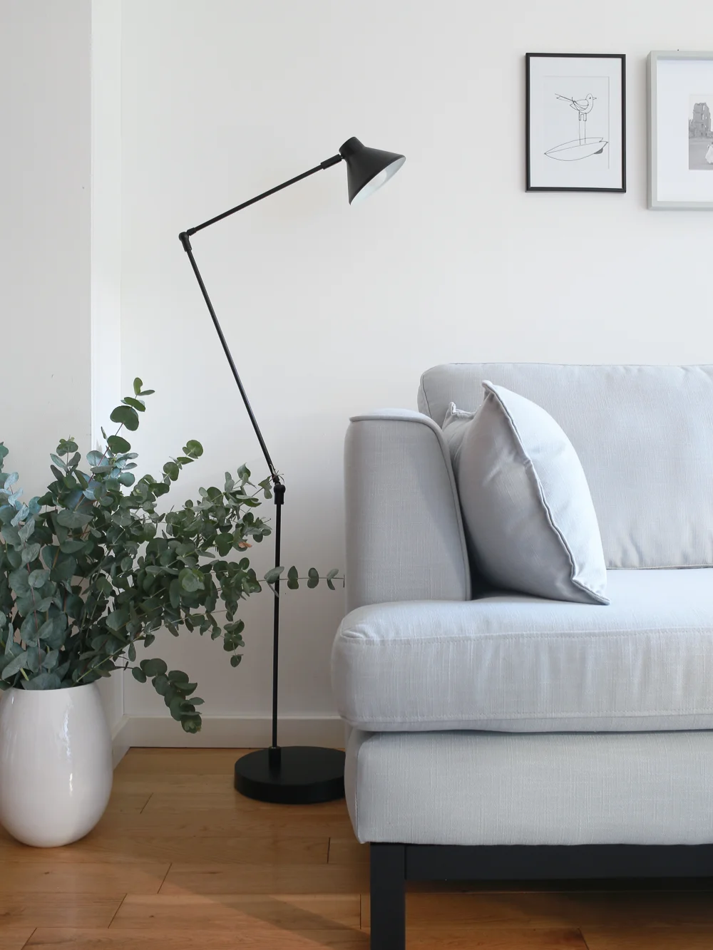 Pale blue sofa and vase of eucalyptus