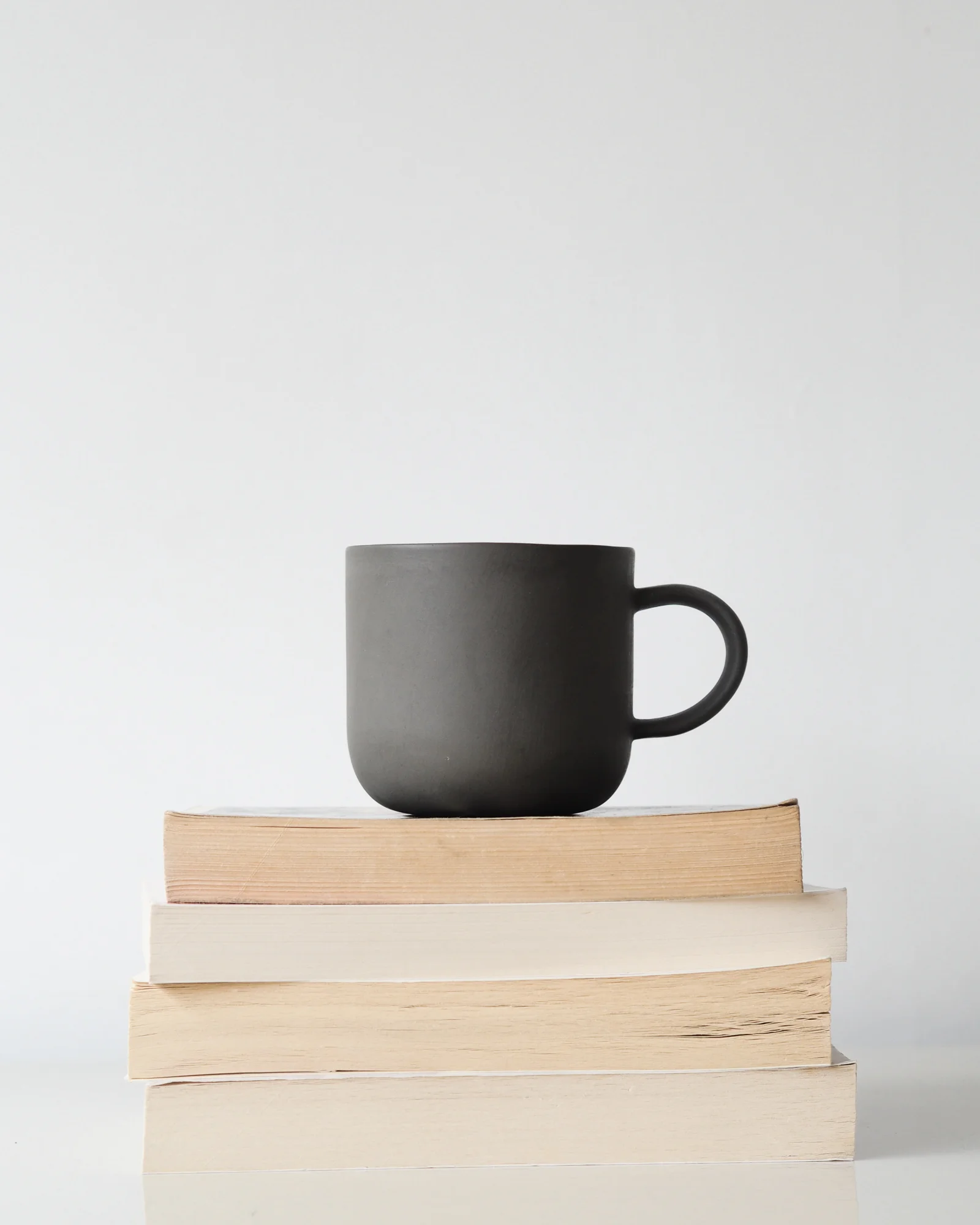Books and grey mug