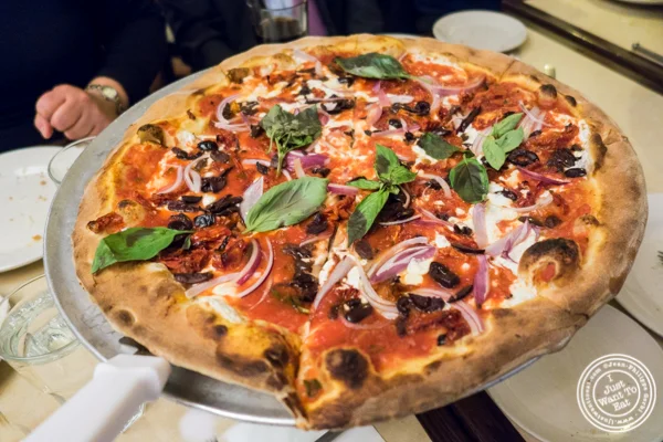Sun dried tomatoes, onions and olives pizza at Angelo's Pizza in NYC, NY