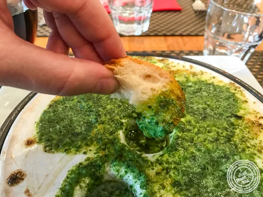 Dipping bread in the Cassolette d'escargots at La Petite Idée, Grenoble, France