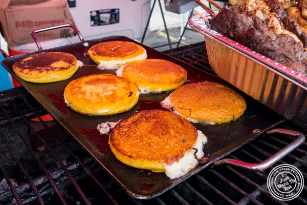 Mozzarepas cooking on a griddle at Chuzos at LIC Flea and Food Market 