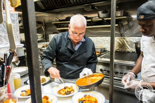Chef Bernard Ros plating a bouillabaisse at Paname, French restaurant, in NYC, NY