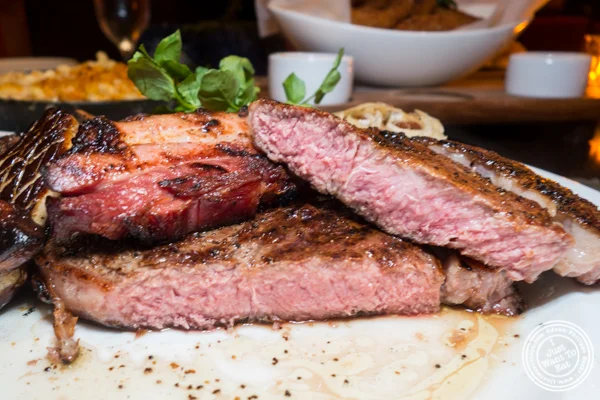 Cowboy bone-in ribeye at Butcher and Banker steakhouse in NYC, NY