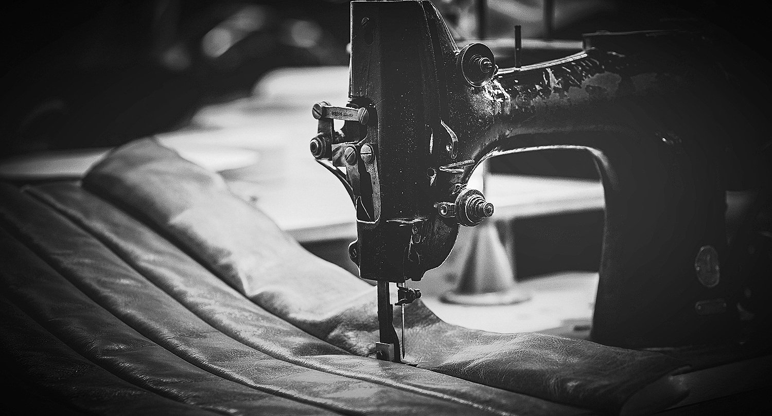 Wanaka Upholstery - Black and white photo of a vintage Singer 132K6 sewing machine sewing leather seat panel.