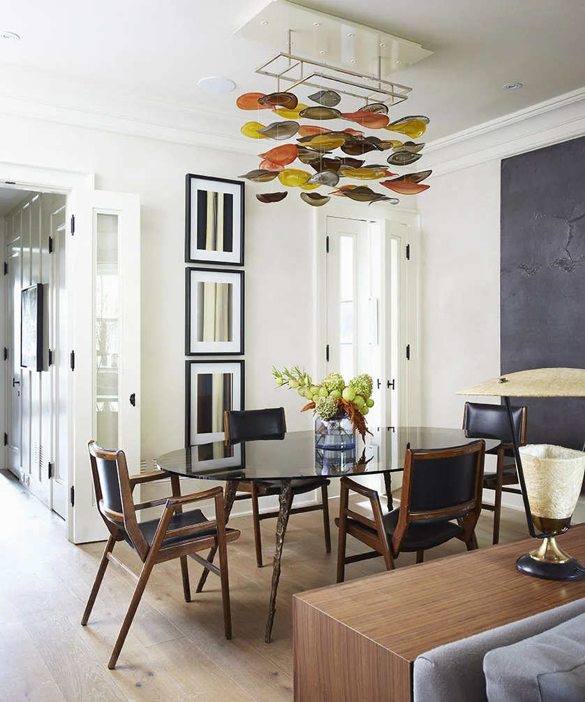 Originally 5 feet deeper, this dining room was awkwardly capacious and square. Creating a more functional layout, the 5 feet was taken to create a butler’s pantry, closet and powder room, which are normally rare features for homes in the surrounding historic neighbourhood. Carrying through the home’s eclectic mix of old and new, 1940’s office chairs provide restful seating around a custom designed smoked glass dining table with molten bronze legs. A unique, custom light fixture from Jeff Goodman Studio provides a soft glow, while reclaimed European oak flooring adds warmth to the room.