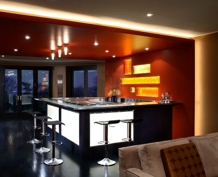 This client wanted his new home to celebrate his North American achievements and European heritage. After conceiving all the interior volumes and spaces, we used a variety of motifs, textures and patterns so that each room has its own mood yet a common richness unites the home. Here, strong colours, high gloss surfaces and light make its “fire and ice” themed lower level lounge an exciting entertainment space.