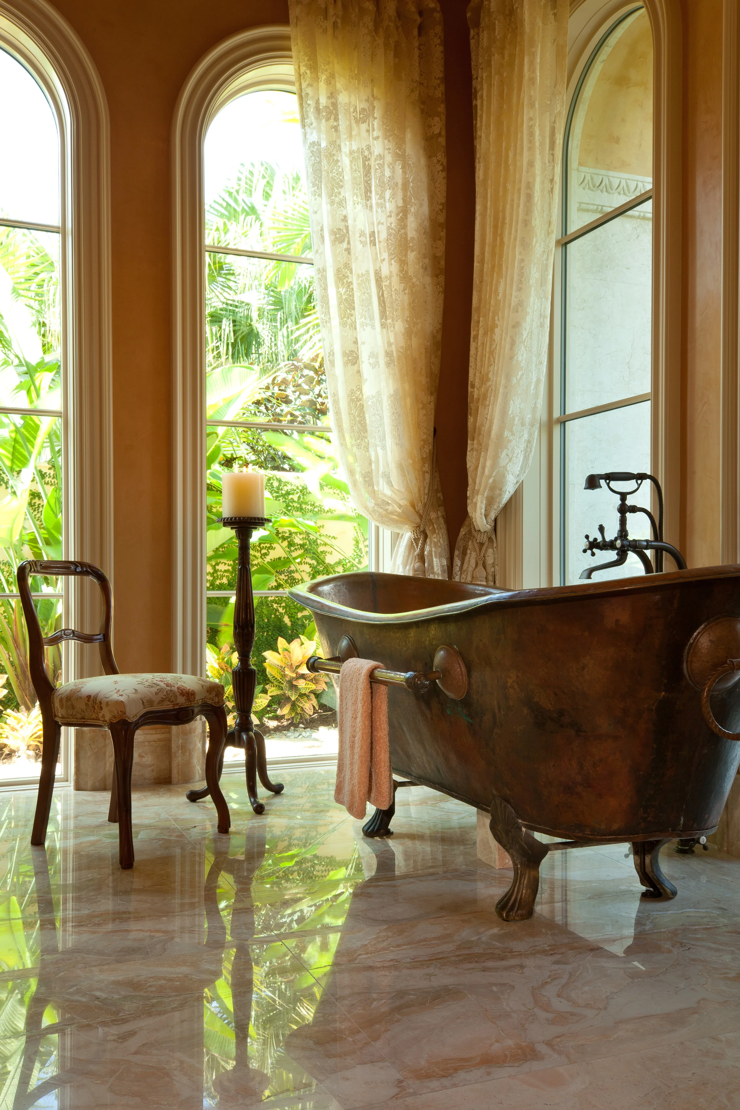 There is a view to a secluded courtyard from the antique French copper tub in the master bath of a remarkable Florida home, which is characterized by superbly detailed millwork.