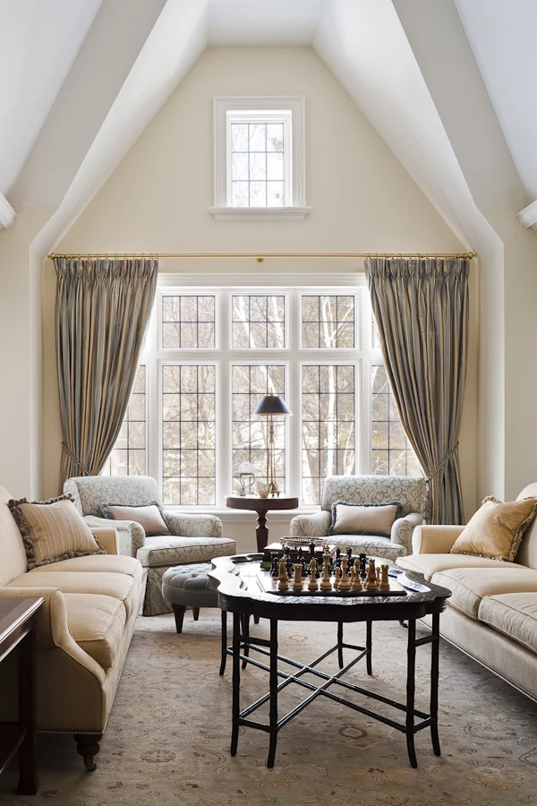 We worked with the builder of this very traditional home to resolve and sculpt the shape of this 1 ½ storey room under the sloping roof line and then furnished it with generously scaled, lushly cushioned furnishings to create a sense of intimacy despite the lofty space. The result is a light and airy room that still feels cozy.