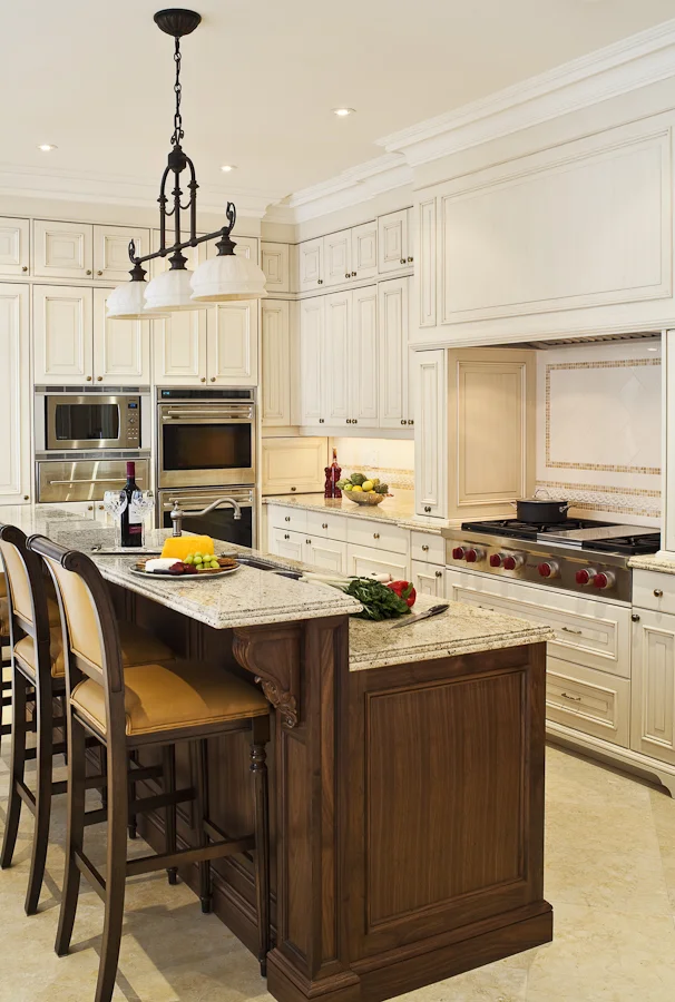 For this custom-built traditional home, we worked closely with the architect to refine the millwork details, then worked with the owners to place and enhance their existing furnishings and art collection. We collaborated with the cabinet maker to develop tidy, controlled and perfectly detailed kitchen storage, centred on a large island, with a raised level concealing the work area and housing electrical outlets. The back splash’s limestone mosaic references the counter top material.