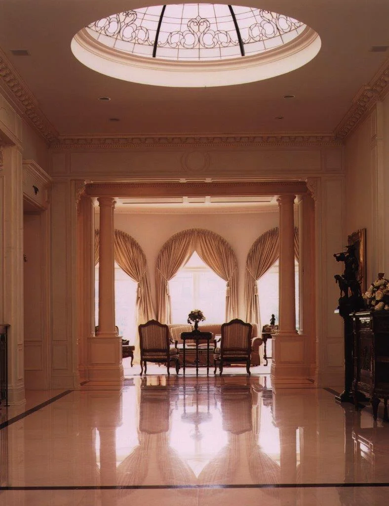 This sophisticated and sociable couple commissioned a grand traditional home to suit their busy family and entertainment lifestyle. With its exquisitely detailed columns, mouldings and cornices, gleaming crema marfil slab flooring bordered by green marble and subtle aged rubbed art wall finish, the grand reception hall is the focal point for the interior. We designed a custom-fabricated leaded glass convex lens to finish the skylight and create a brilliant conservatory effect.