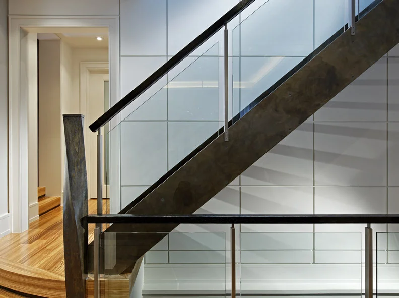 This clean, open and contemporary interior responds to this young family’s modern tastes, but references the traditional exterior elements, grey-brown stone / black-brown trim, in elements such as the flooring material and stair’s dark steel patina. The stair structure floats from and contrasts with the wall panels, floating glass panels float within its railing.