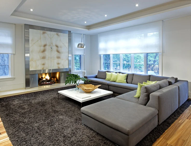 The generous and comfortable family room is awash with natural light in daytime and bathed in the glow of the backlit onyx fireplace later when the blinds fully drop from their concealed housing.