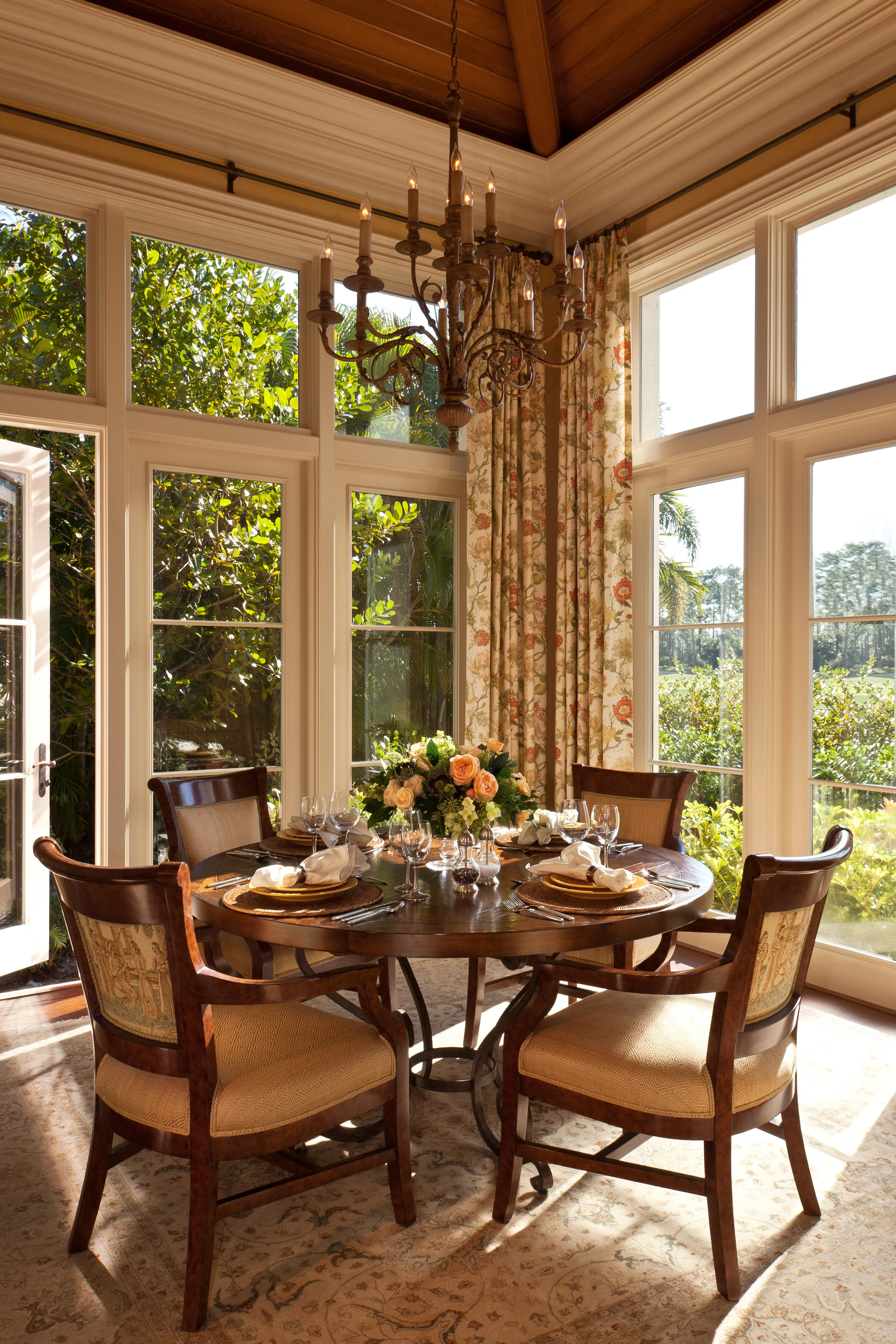 Below the carefully planned beamed cypress wood ceiling and surrounded by hurricane proof windows, this charming breakfast room is filled with Florida sunshine.