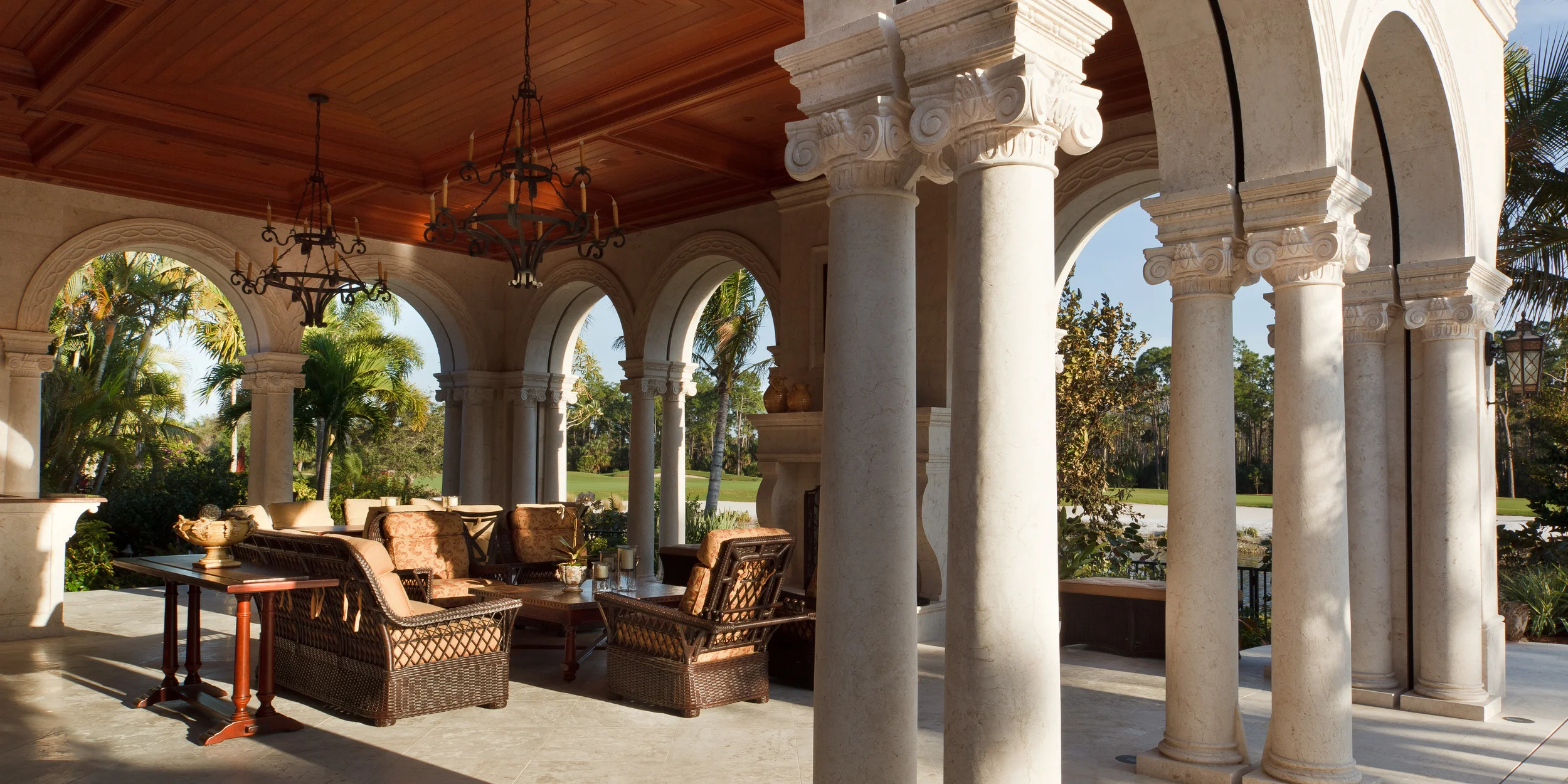 In the welcoming lanai of this Florida home, the columns and ceiling are typical of the extensive design detailing. Here, narrow slots between the double columns conceal remote controlled widow screens.