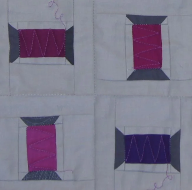 Detail of Spools. The spool upper right is Kona Cerise, the lower Right is a Blue Purple
