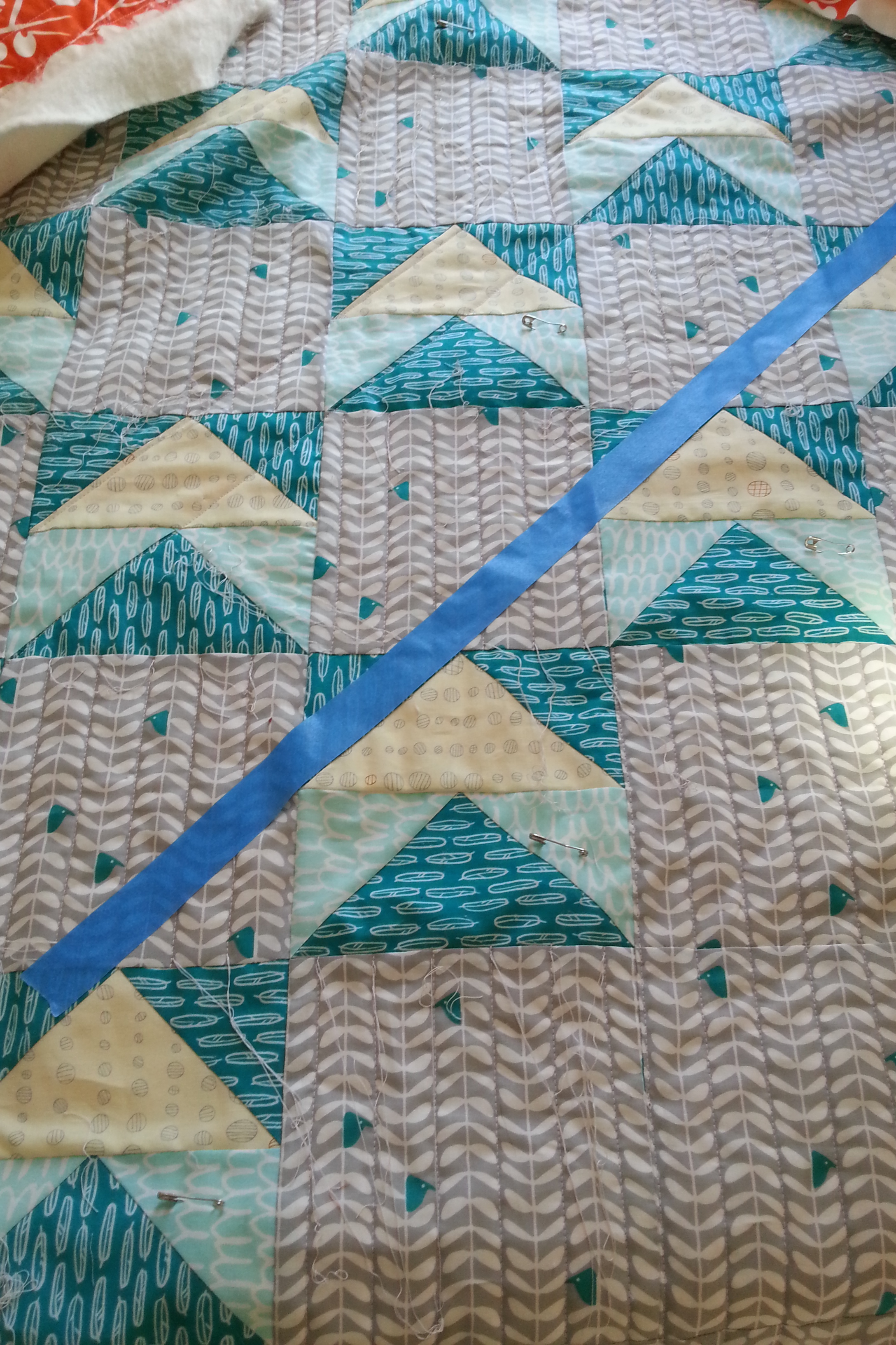 Painter's tape on the "Early Birds" quilt, ready for quilting a long diagonal line