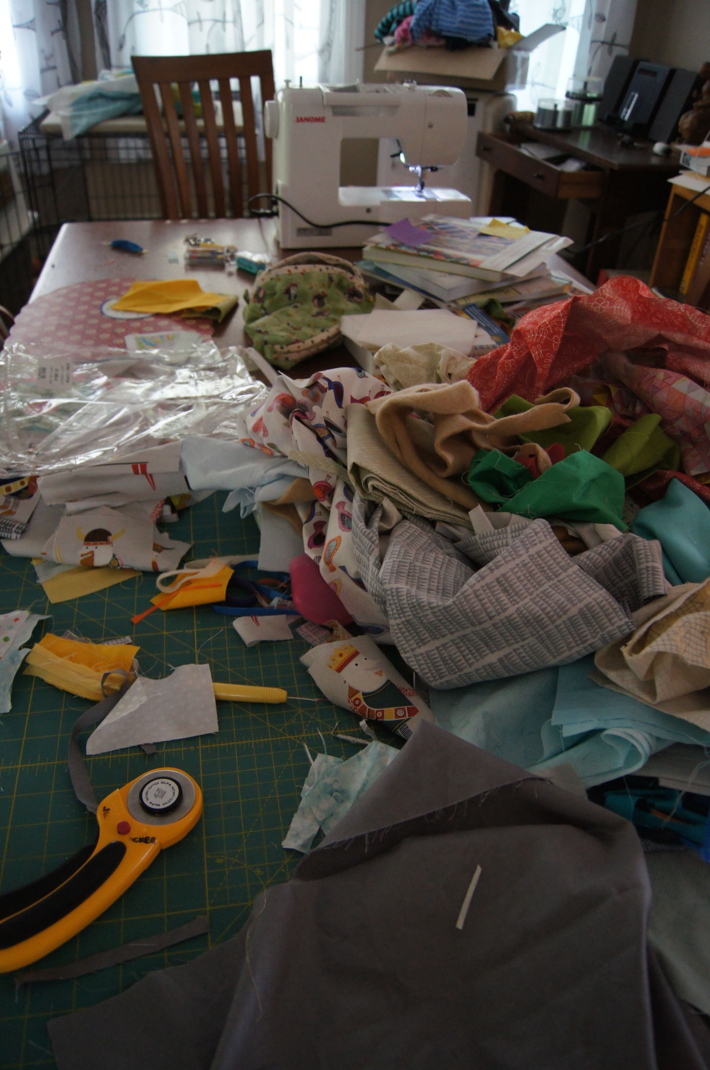 Creative cutting mess on my dining room table. It looks like a mess but the fabrics are organized by color and/or location in a section in the quilt. The fussy cut pieces are in a separate stack.