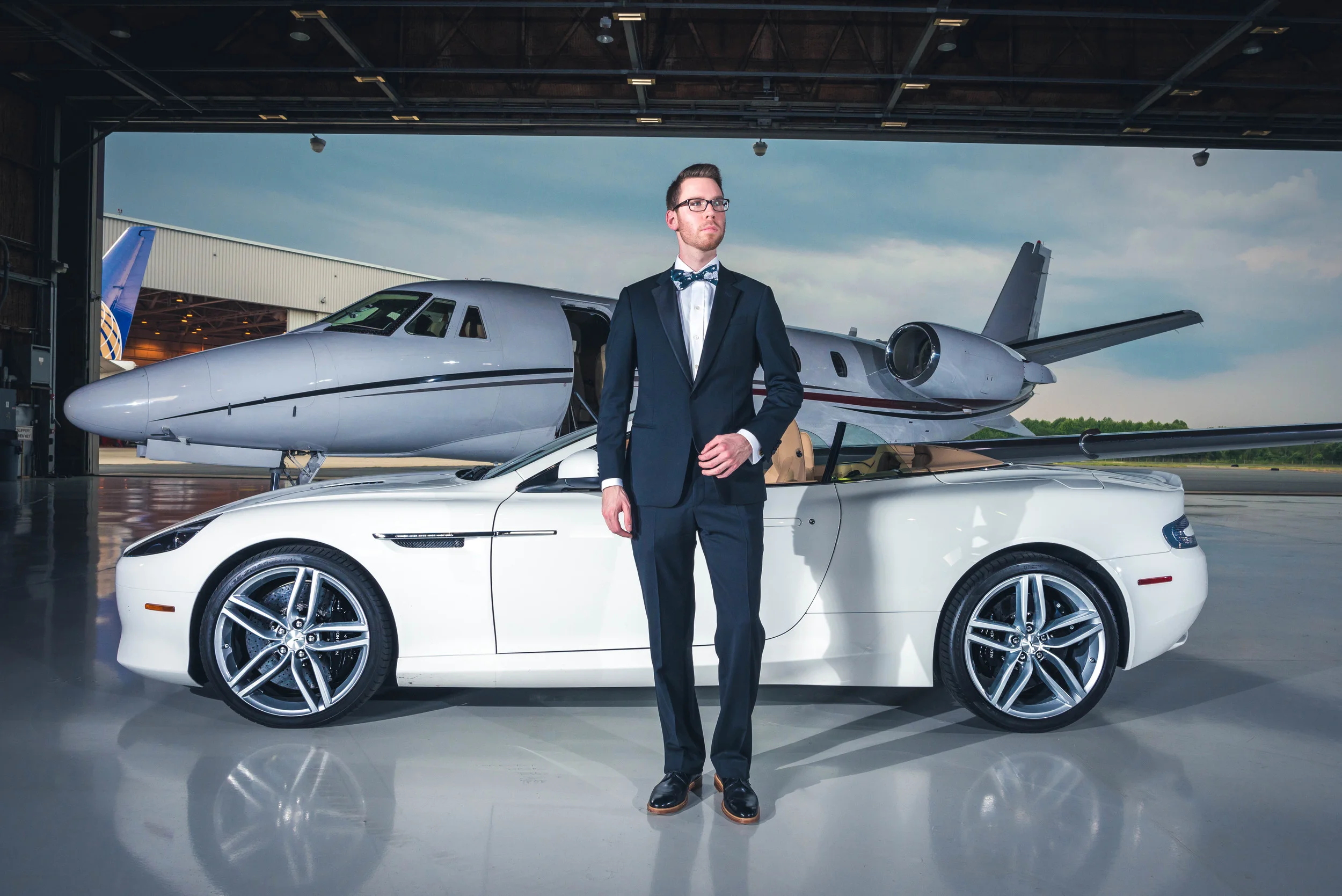 Tuxedo: Armani Collezioni(courtesy Saks Fifth Ave.), Shirt: Ledbury, Tie: The Tie Bar, Shoes: Crosby Square, Glasses: Burberry, Car: 2014 Aston Martin DB9 Volante(courtesy Foreign Cars Italia), Photo: Alec Hutchins Photography, Model: Noah Will…