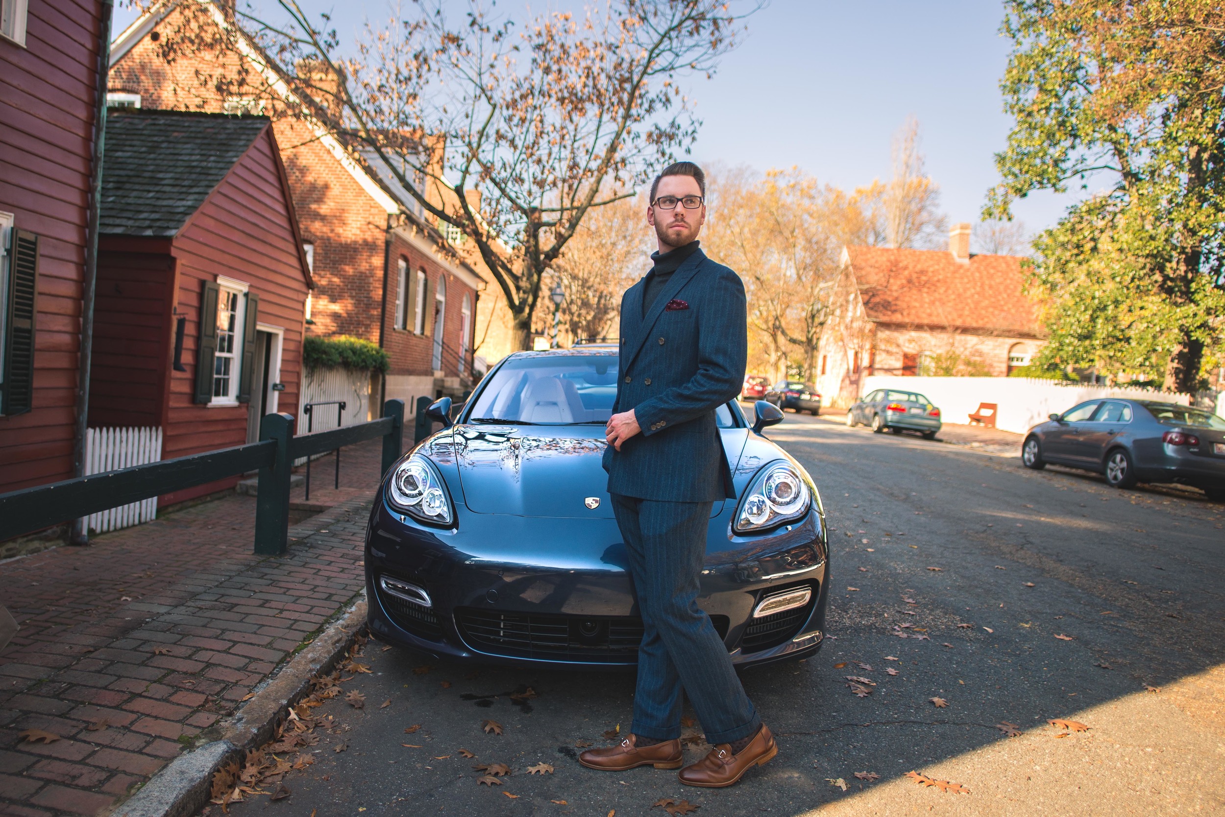 Suit: Indochino, Shoes: Johnston & Murphy, Glasses: Burberry, Sweater: Ralph Lauren, Car: 2010 Porsche Panamera Turbo courtesy of Foreign Cars Italia Greensboro, Photo: Alec Hutchins Photography. 