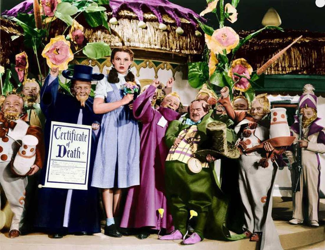 Judy Garland surrounded by The Munchkins.
