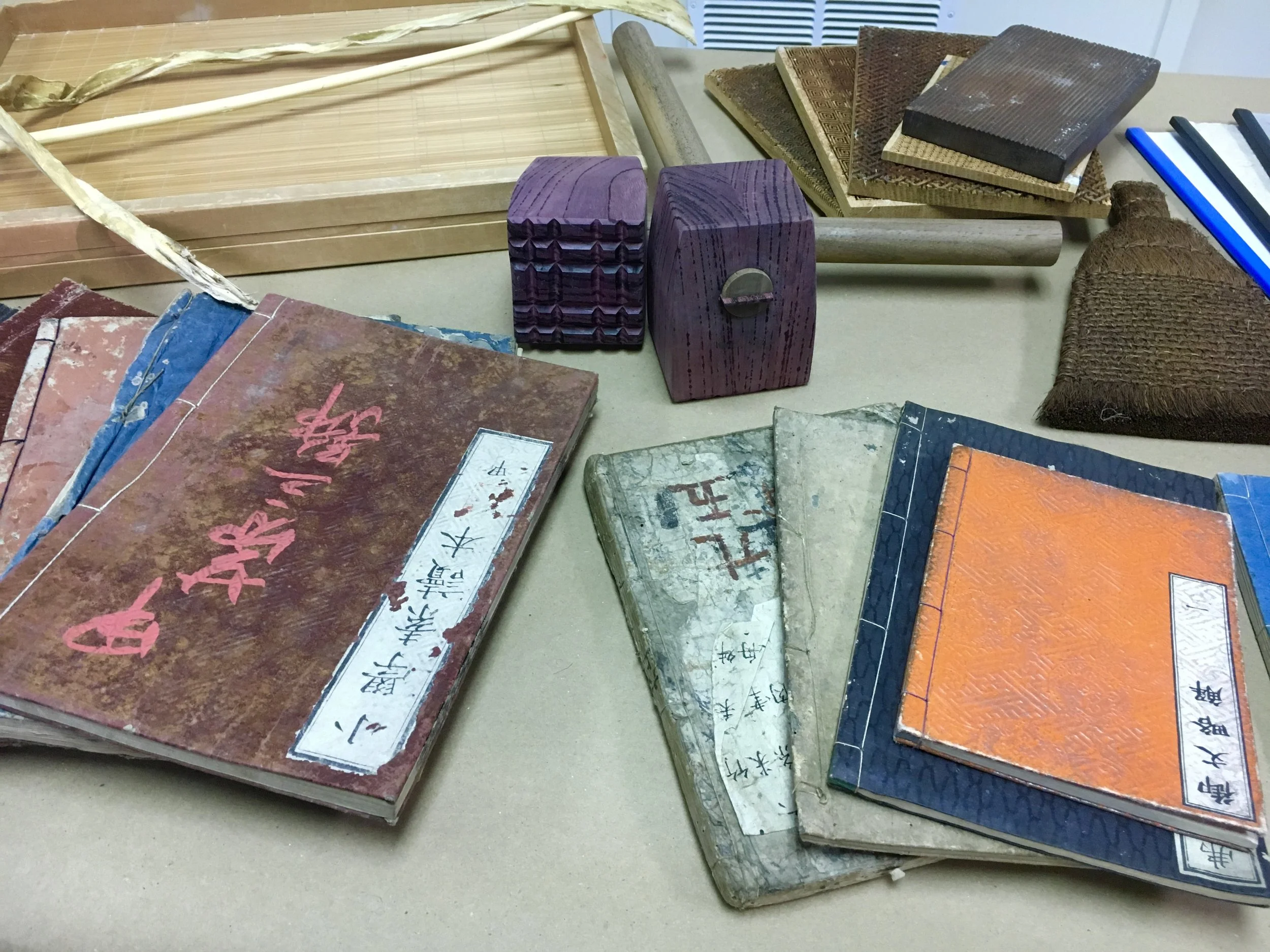 A collection of vintage Japanese notebooks and wooden stamps on a table.