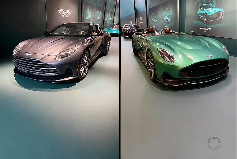 Two luxury cars displayed on a green resin showroom floor.