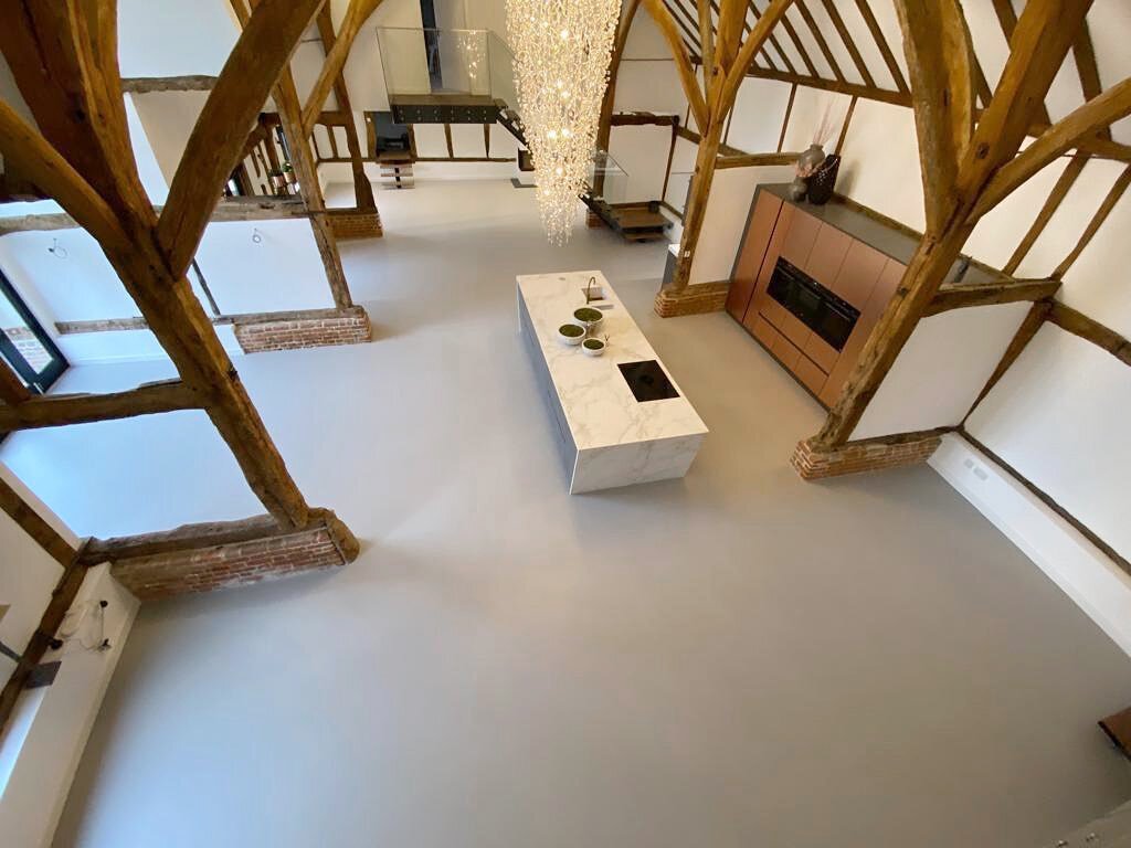 The spacious interior of a barn conversion features a 165m2 PU Resin Floor in mid grey. Stylish and practical, resin floors are very good at absorbing ambient heat and retaining warmth, making them ideal for homes like this. 

If you would like to kn