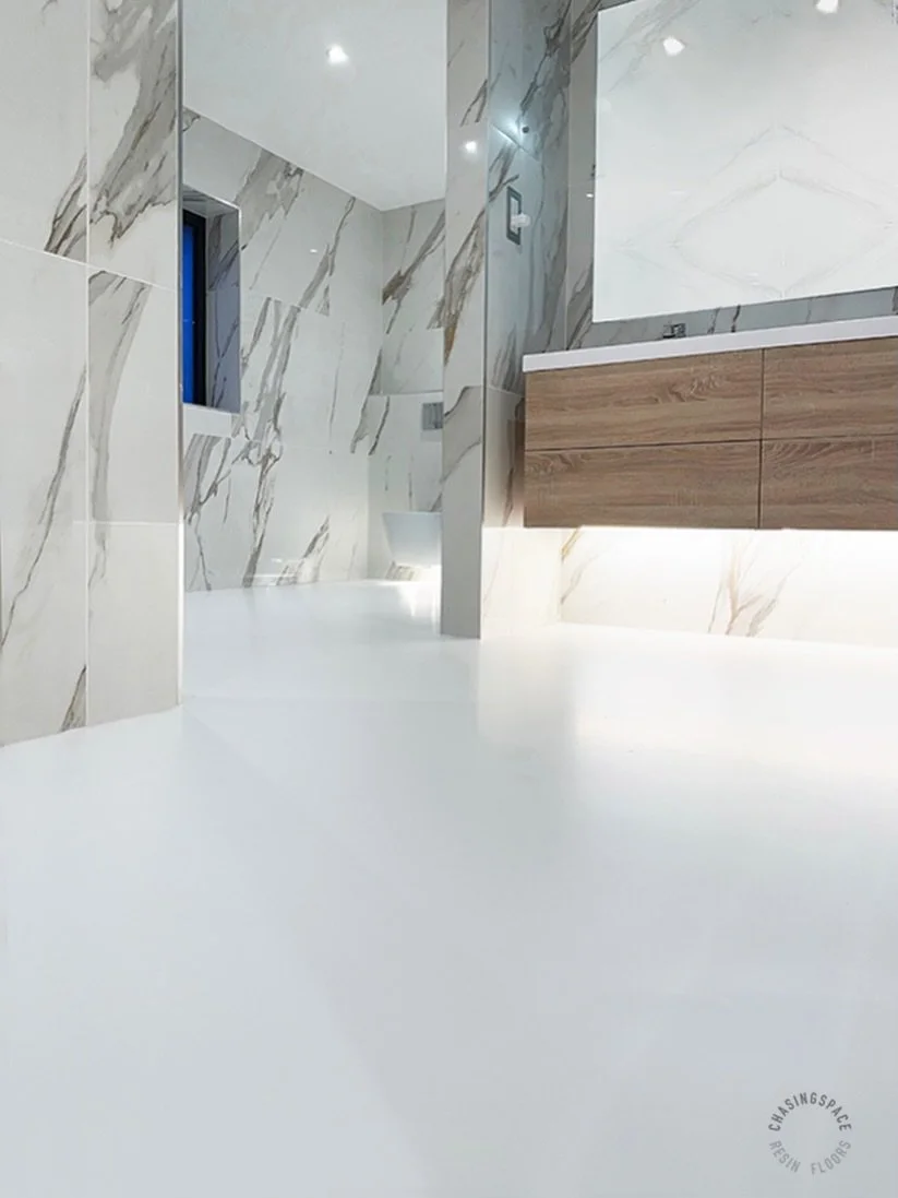 A durable white PU resin floor in a modern bathroom🚿

It enhances the space with a clean, bright look that beautifully complements the marble walls.

The right flooring can truly transform a room. For more information about our bathroom/wet room flo
