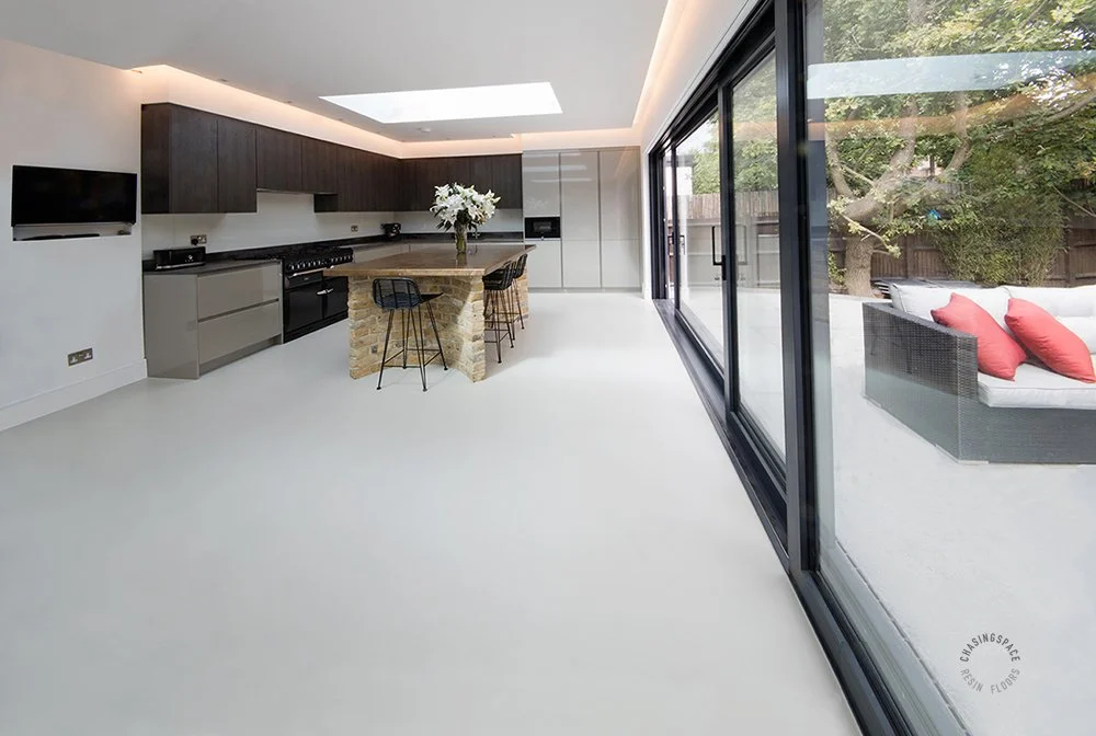 High-end kitchen with a smooth, continuous grey resin floor.