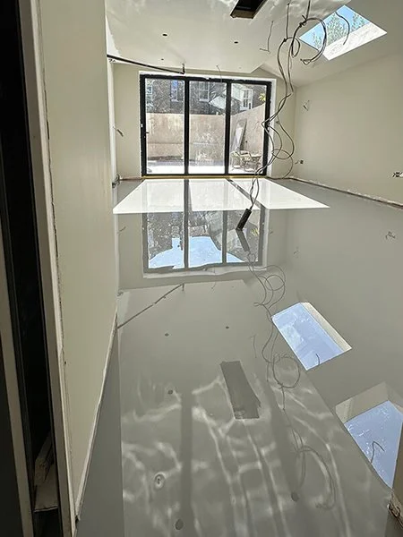 Freshly poured, high-gloss grey resin floor.