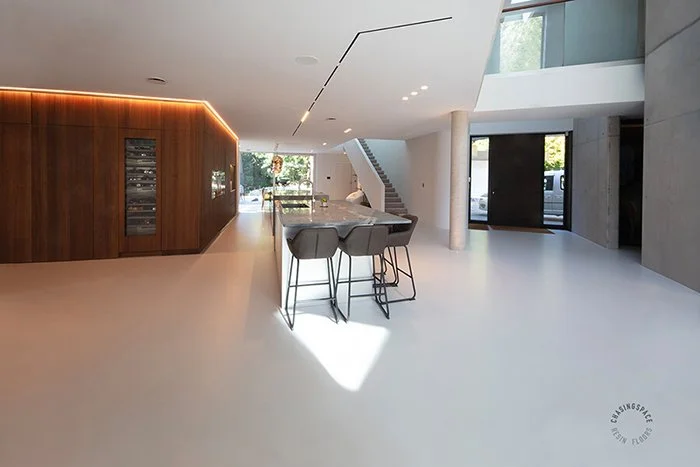 Continuous resin surface creating a bright, unbroken flow through a luxury home interior.