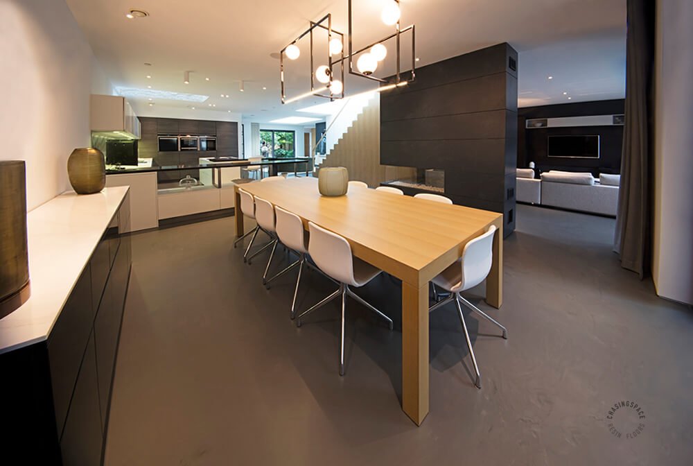 Contemporary interior with a black and white color scheme. The resin flooring complements the large windows, enhancing the open plan layout.