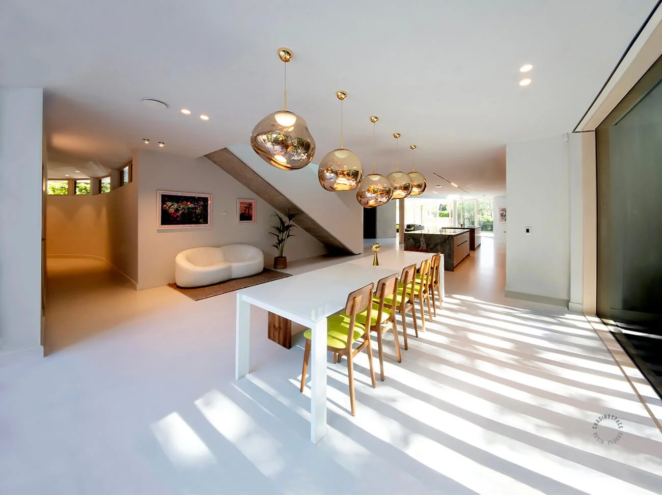 Seamless light grey resin flooring provides a sleek foundation for a sunlit living space.