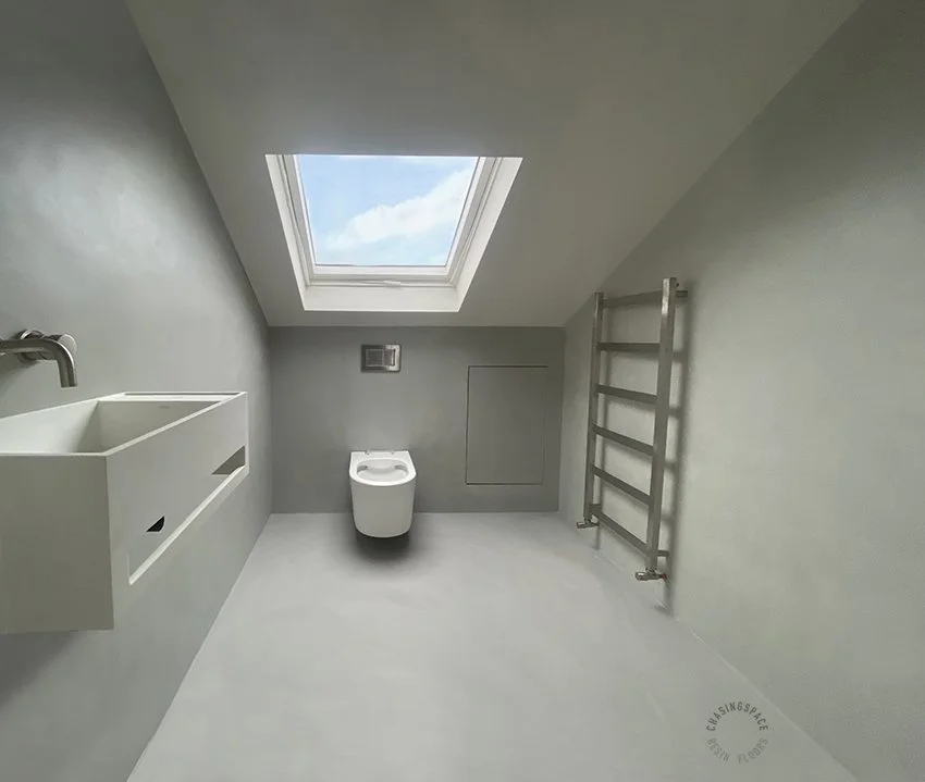 Grey-toned microcement walls and resin flooring in a modern bathroom.