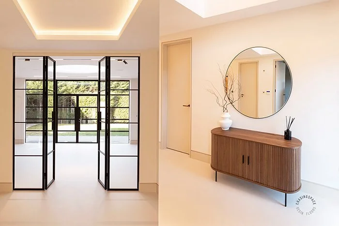 Contemporary interiors feature seamless resin flooring, architectural glass partitions, and a chic entryway vignette.