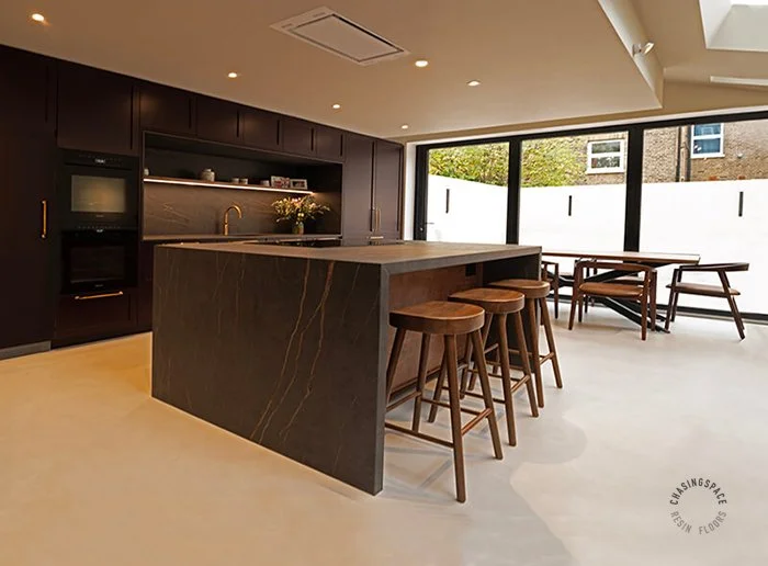Seamless, off-white resin flooring anchoring a luxury kitchen.