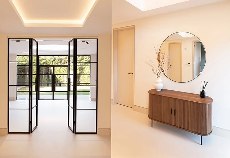 A sleek, light-coloured resin floor seamlessly connects the modern hallway and entryway, enhancing the minimalist aesthetic.