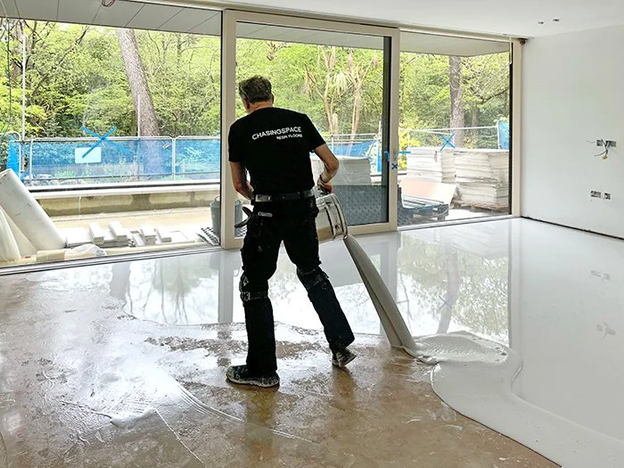 Expertly applying poured resin to create a stunning resin floor in Poole, UK, transforming the space with both functionality and elegance.
