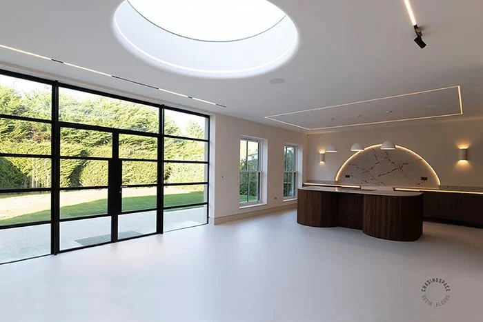 Expansive modern kitchen diner featuring a seamless light grey resin floor.