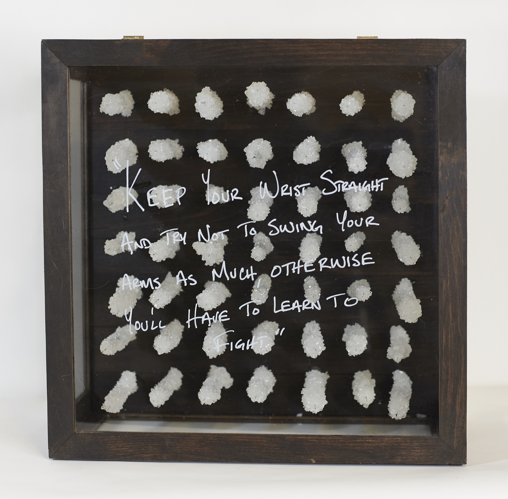 Placebo #2 2015 Syringe, crystallized sugar, saline, charcoal*, wood, glass, chalk *Mixed with the urine, blood, semen, and saliva of the artist. The placebo effect and the idea of self-medication are the driving concepts within this piece. Placebo #2 is much more individualized and is a response to something my father said to me when I told him I was being called a faggot in grade school. The syringes are crystallized in sugar as a parallel to the sugar in the capsules in Placebo #1. Each syringe is also filled with a handmade charcoal that has been mixed with the artist’s urine, blood, semen, and saliva. The charcoal is meant to symbolize the naïve, grade-school, definition of faggot as being a burning bundle of sticks and to describe the cyclical nature of self-hatred in regards to self-medication.