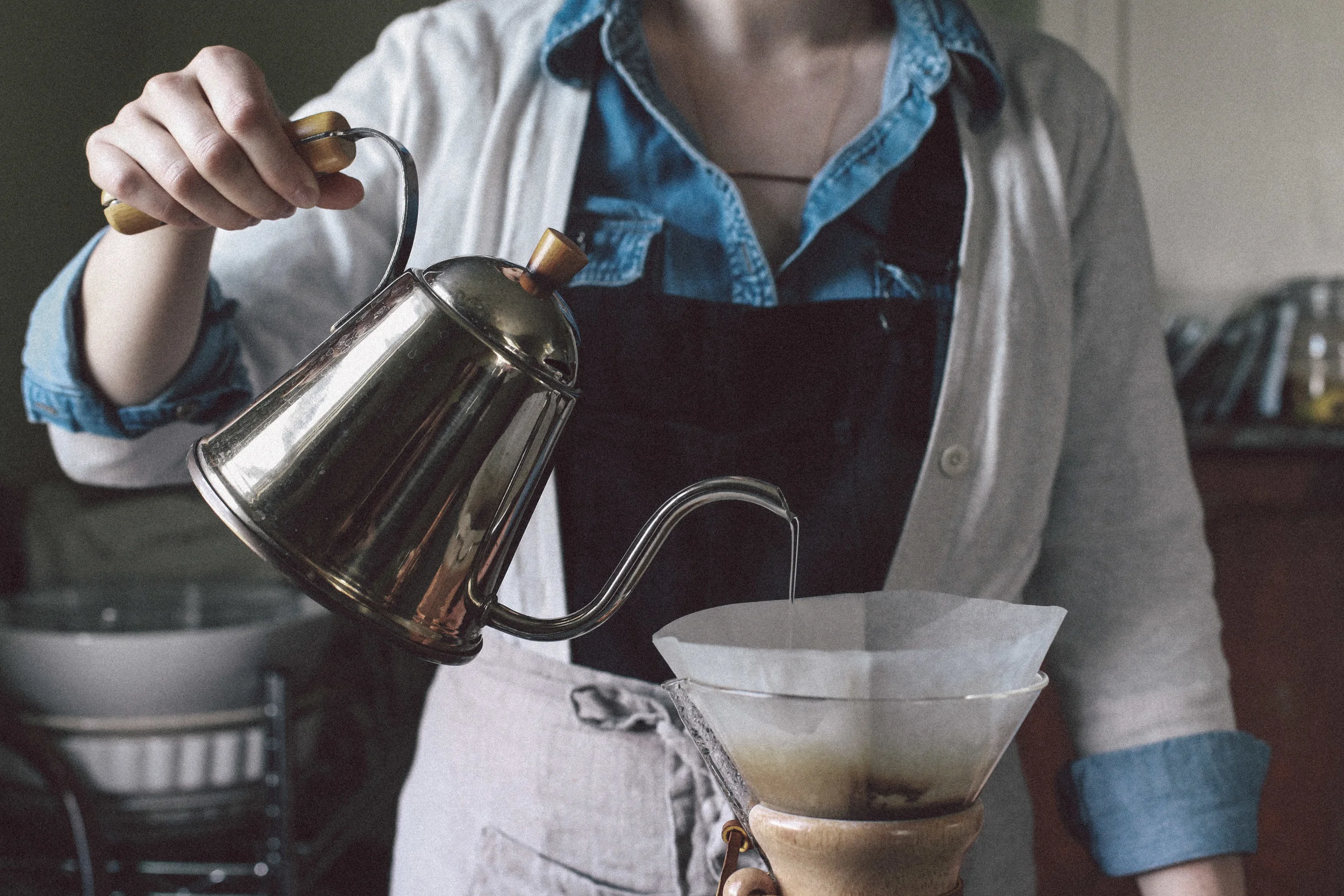 Preparing coffee from start to finish is a delicious experience for the senses - grinding the beans, boiling the water, blooming your coffee grounds, and taking great care to produce the perfect cup. Rebecca is seen here wearing Consider The Wldflwr's bronze bar necklace .