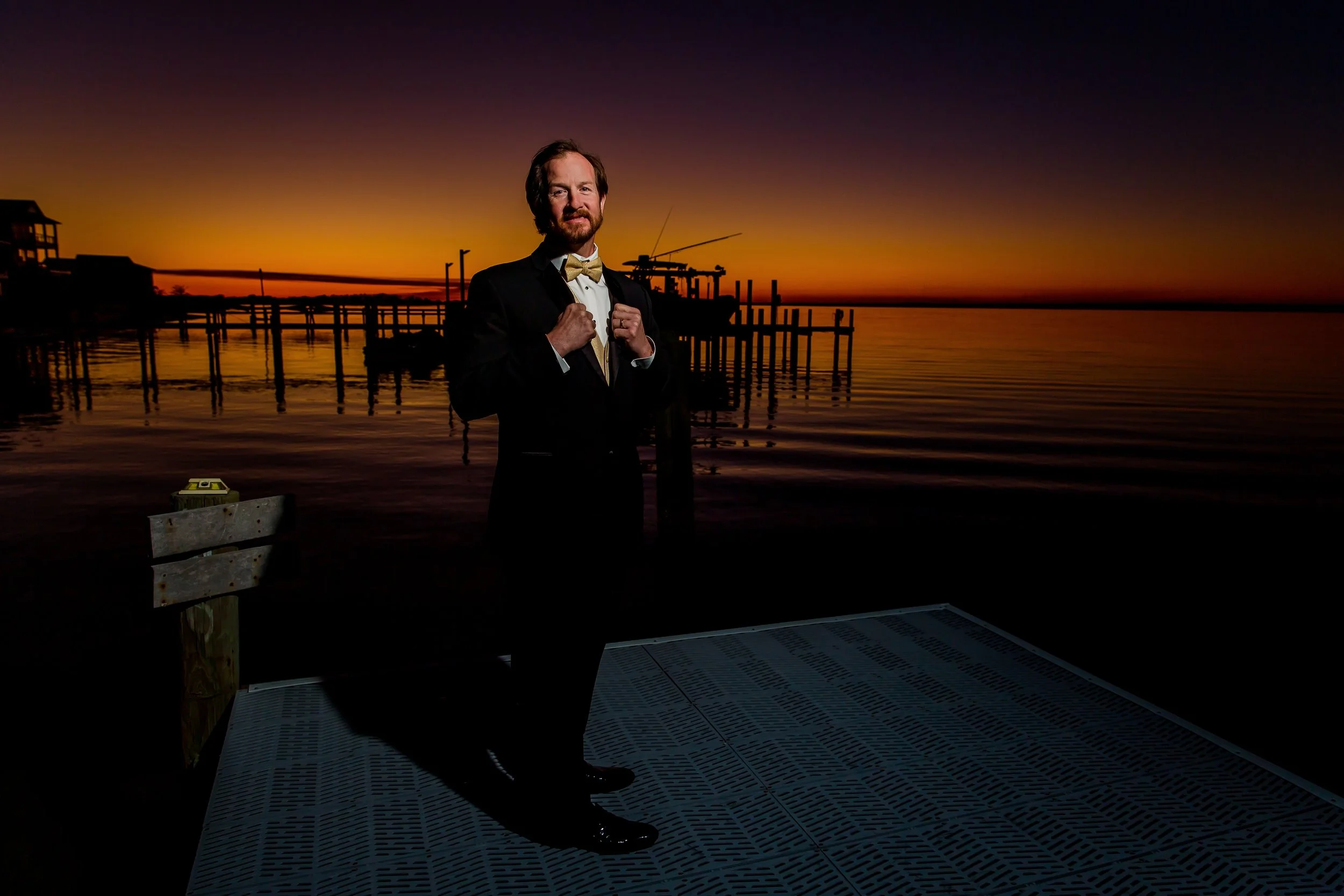 Groom standing alone for a portrait on a Navarre Beach dock taken by a Jacksonville Florida Photographer